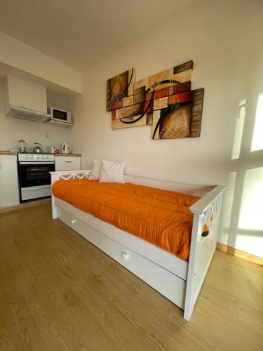 a bedroom with a bed with an orange bedspread at NUEVO Departamento 2 Ambientes in Mar del Plata