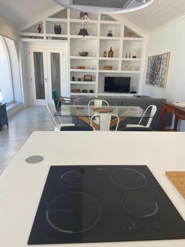 Casa Pitta Charm Villa في شنترين: مطبخ وغرفة معيشة مع طاولة وكراسي