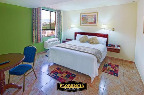 a bedroom with a bed and a table and chairs at FLORENCIA PLAZA HOTEL in Tegucigalpa