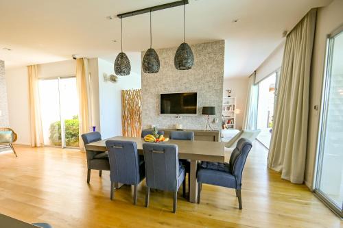 une salle à manger avec une table et des chaises bleues dans l'établissement GIULIA, Villa d'exception, Piscine vue mer - Porticcio, à Porticcio