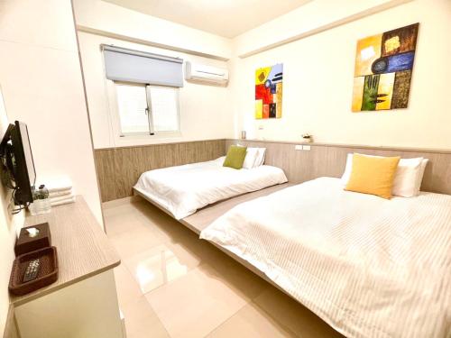 Habitación con 2 camas y TV. en 八八古藝悅禾民宿, en Jinning