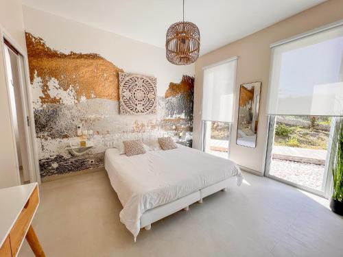 une chambre blanche avec un lit et un tableau au mur dans l'établissement GIULIA, Villa d'exception, Piscine vue mer - Porticcio, à Porticcio