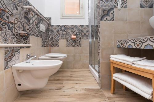 a bathroom with a toilet and a sink and a shower at Sisula Country Hotel & SPA in Orosei