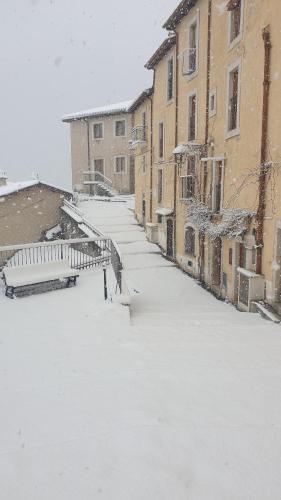 a snow covered street in a city with buildings at Casavacanza al castello 2 in Villetta Barrea