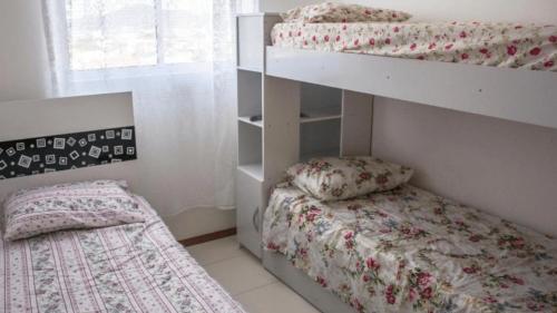 um quarto com 2 beliches e uma cama em Lindo Apartamento, amplo e confortável, Penha Santa Catarina, em Penha