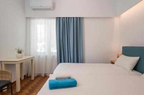 a bedroom with a large white bed and a desk at Hermes Beach Front in Stalos