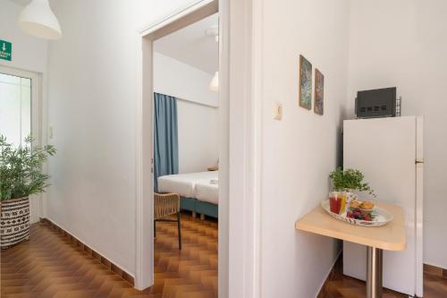 a room with a refrigerator and a table and a bed at Hermes Beach Front in Stalos