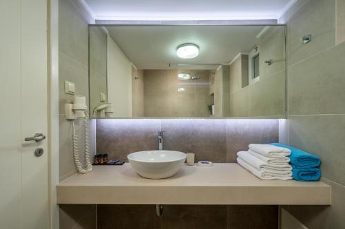 a bathroom with a sink and a mirror at Hermes Beach Front in Stalos