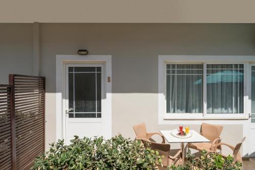 a patio with a table and chairs in front of a building at Hermes Beach Front in Stalos