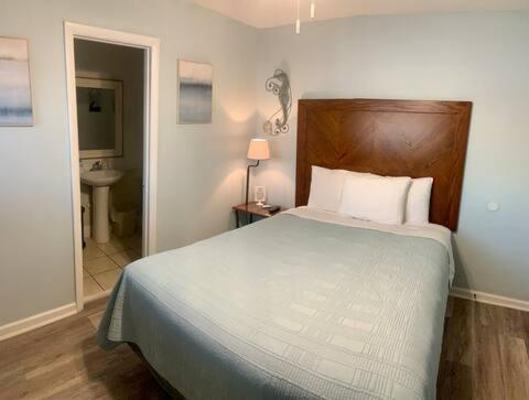 a bedroom with a bed and a bathroom with a sink at Waterway Inn in Cedar Point