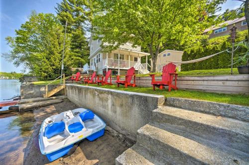 a boat sitting on the water in front of a house at Lake Luzerne Home with Fire Pit on Hudson River in Lake Luzerne