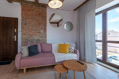 a living room with a purple couch and a table at Przy Poznańskiej Bramie in Inowrocław