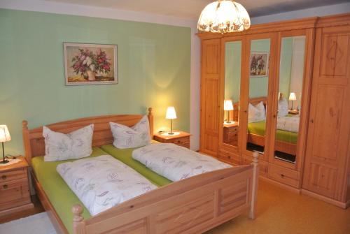 a bedroom with a large wooden bed with white pillows at Ferienwohnung Am Untermarkt in Mittenwald