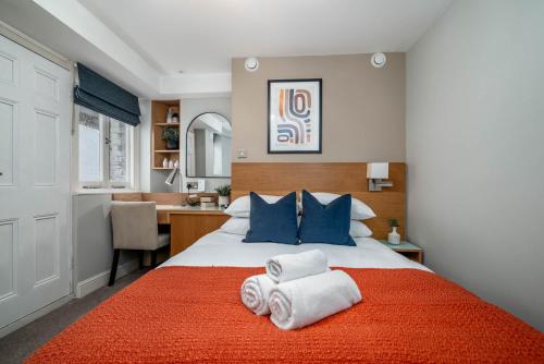 a bedroom with a bed with towels on it at 5 Doughty Street - Urban Apartments in London
