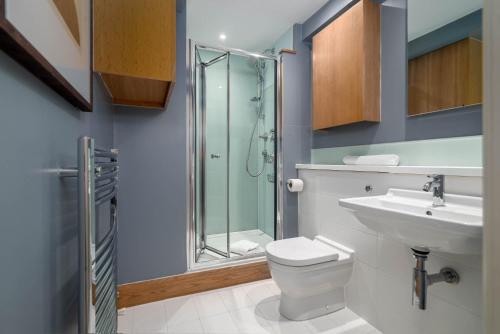 a bathroom with a shower and a toilet and a sink at 5 Doughty Street - Urban Apartments in London