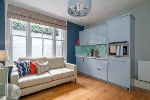a living room with a couch and a kitchen at 5 Doughty Street - Urban Apartments in London