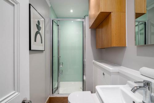 een badkamer met douche, toilet en wastafel bij 5 Doughty Street - Urban Apartments in Londen