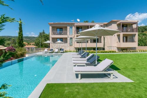 a villa with a swimming pool with lounge chairs and an umbrella at Neoma Luxury Residence - Adults Only in Sivota