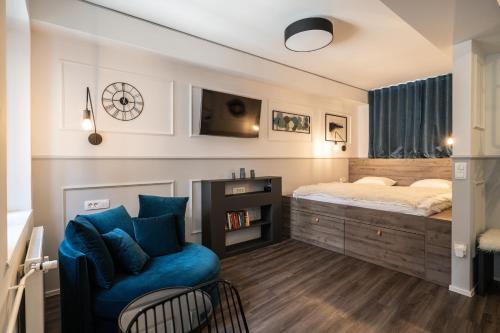 a bedroom with a bed and a blue chair at Strict city apartments in Ljubljana