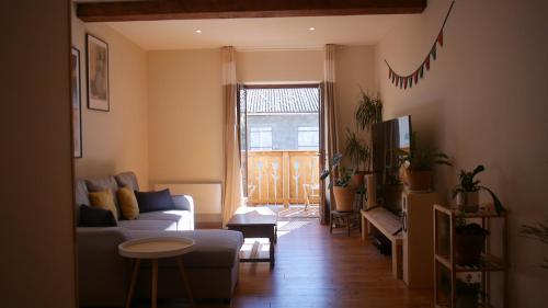 a living room with a couch and a table at L'Oustal des amis in Belcaire