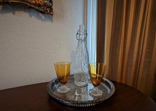 a tray with two glasses and a bottle on a table at The 1890 Freeman House in Galveston