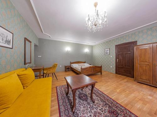 a living room with a yellow couch and a table at Hotel Salamander - Garni in Banská Štiavnica