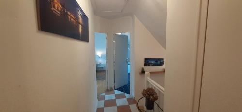 a hallway with a staircase with a checkered floor at Tous à l'ouest in Combrit