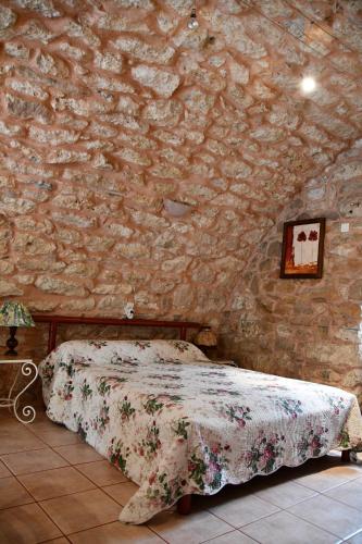 1 dormitorio con 1 cama en una pared de piedra en Gîte Domaine du Théron, en Mostuéjouls