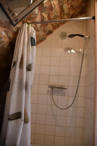 y baño con ducha con cortinas blancas. en Gîte Domaine du Théron, en Mostuéjouls