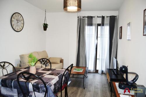 sala de estar con cama, sofá y reloj en Caseria de Comares Apartments 104 en Granada