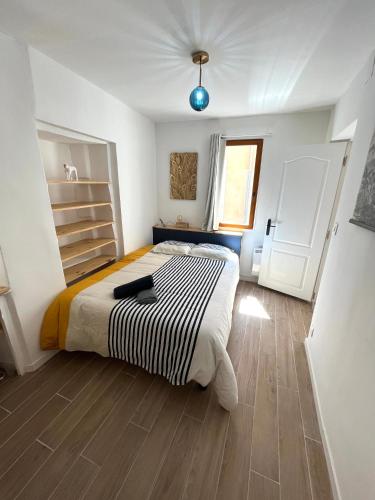 une chambre avec un lit avec une couette noire et blanche dans l'établissement Nuit bleue - tout Grasse à pied !, à Grasse