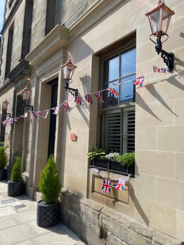 un edificio con banderas británicas a su lado en Newgate House en Morpeth