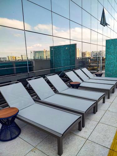 a row of chaise lounges on the roof of a building at Ramada by Wyndham Brasilia Alvorada in Brasilia