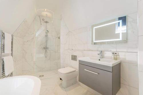 a white bathroom with a toilet and a sink at The Old School Room - The Lace Market in Nottingham