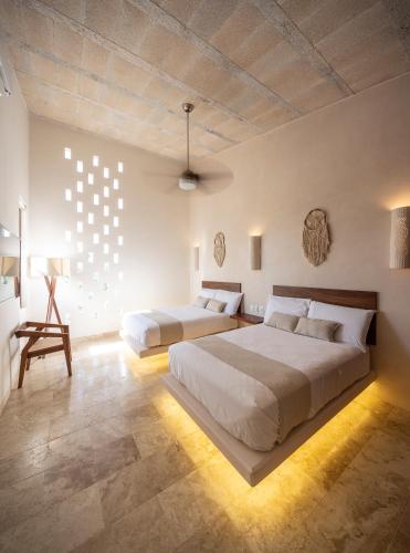 a bedroom with two beds and a chair in it at Kiki Tulum in Tulum