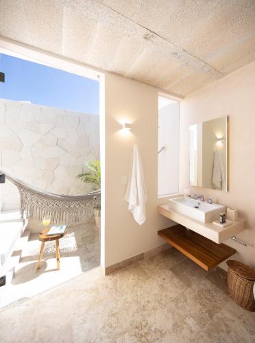 a bathroom with a sink and a mirror at Kiki Tulum in Tulum