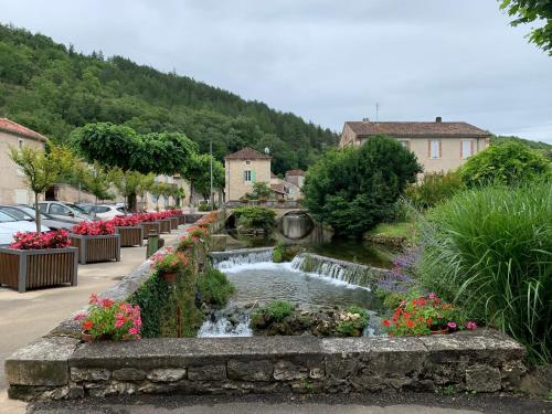 a small town with a waterfall and flowers at Spacious apartment in a charming, tranquil village in Saint-Vincent-Rive-dʼOlt