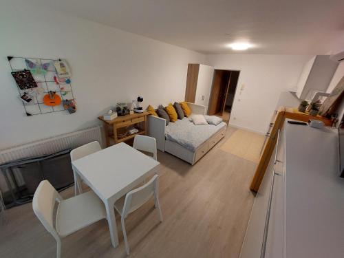 een woonkamer met een bed en een tafel en stoelen bij Apartma DU32 in Moravske-Toplice