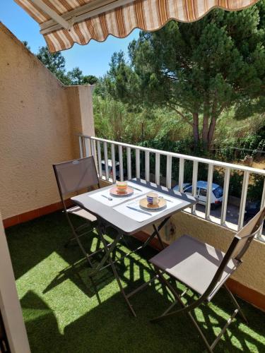 - un balcon avec une table et deux chaises dans l'établissement 11 le tadorne, à Aigues-Mortes