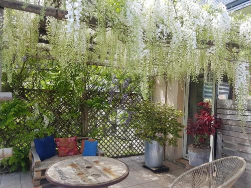 a patio with a table and chairs and flowers at Tous à l'ouest in Combrit
