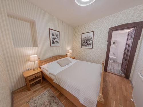a bedroom with a large white bed and a mirror at Hotel Salamander - Garni in Banská Štiavnica