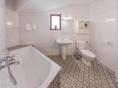 a bathroom with a tub and a toilet and a sink at Hotel Salamander - Garni in Banská Štiavnica