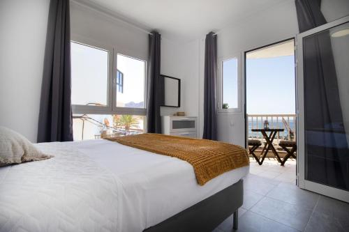 een slaapkamer met een groot wit bed en ramen bij Casa Playa Chica in Gran Tarajal