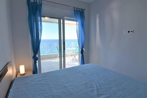 a bedroom with a bed and a view of the ocean at Magic Balcony on Siviri Chalkidiki. in Siviri