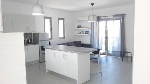 a kitchen with white cabinets and a table and chairs at Kalavarda Cosy Home 1 in Kalavárda