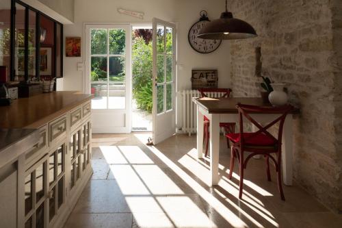 une cuisine avec une table et une chaise rouge dans l'établissement La Martinoise Garden, à Saint-Martin-de-Ré