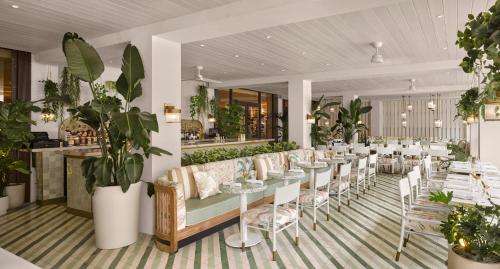 a restaurant with tables and chairs and plants at PGA National Resort in Palm Beach Gardens