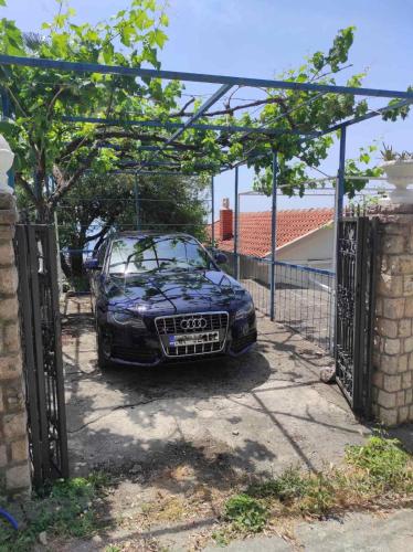 a car parked under a gate in a driveway at Apartman Mali Pijesak in Bar