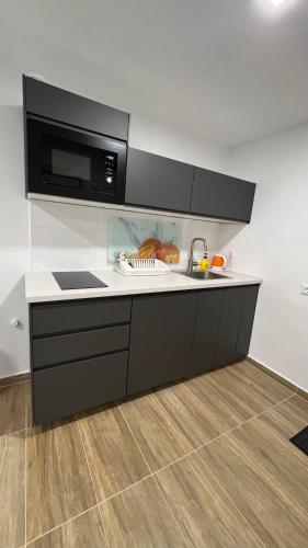 una cocina con fregadero y microondas en Lemon Apartman, en Harkány
