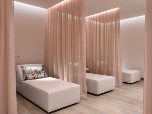 a living room with two white chairs and curtains at PGA National Resort in Palm Beach Gardens